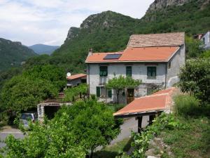 a house on a hill with mountains in the background at AGRITURISMO I LAMOI in Finale Ligure