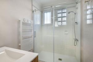 a white bathroom with a shower and a sink at Maison avec jardin à 140m de la Plage in Saint-Michel-Chef-Chef +10 photos