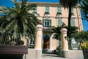 a house with a palm tree in front of it at B&B Agapantus in una Villa dell'800 in Dolceacqua