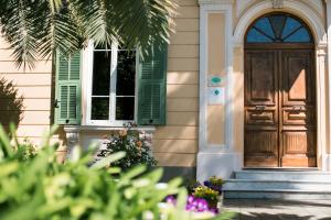 a house with a wooden door and green shutters at BB AGAPANTUS in un alloggio per una vacanza da sogno in Dolceacqua