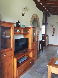 a large wooden entertainment center with a flat screen tv at Casa Collao 24 in Sierra