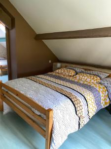 een slaapkamer met een bed met een houten frame bij Chez pépé in Arromanches-les-Bains