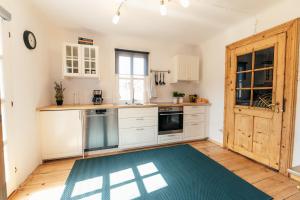a kitchen with white cabinets and a blue rug at s´Manz in Grundlsee