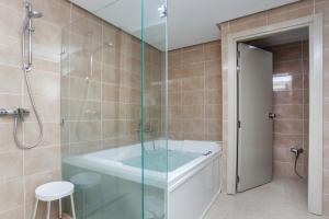 a bathroom with a tub and a glass shower at Hotel Nour Congress & Resort in Bizerte