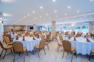a banquet hall with white tables and chairs at The Hotel Unforgettable - Hotel Tiliana by Homoky Hotels & Spa in Budapest