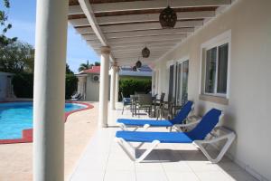 a patio with lounge chairs and a swimming pool at Apartamentos y Villas Michaela in Sosúa
