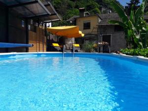 una sombrilla y una silla en una piscina en Barolo, en Gravedona