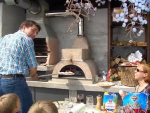 un hombre parado frente a un horno de pizza en Barolo, en Gravedona