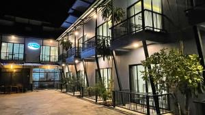 ein Gebäude mit Fenstern und Pflanzen im Innenhof in der Unterkunft Re-Live Resort in Ban Bang Phra