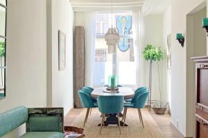 a dining room with a table and blue chairs at Rosier37 in Antwerp