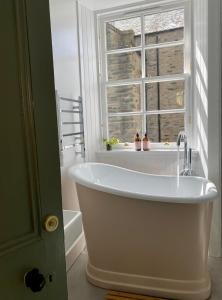 uma banheira na casa de banho com uma janela em The Taybank em Dunkeld