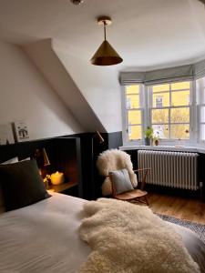 a bedroom with a bed and a chair and a window at The Taybank in Dunkeld