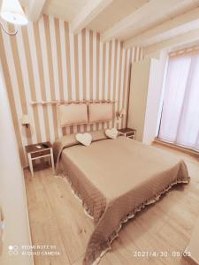 a bedroom with a bed and a striped wall at B&B La Maison Del Borgo Antico in Bari