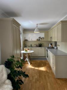 a kitchen with white cabinets and a table in it at The Taybank in Dunkeld