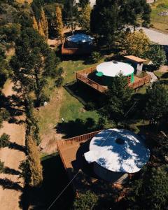 een uitzicht op twee grote hot tubs in een tuin bij Solar do Oriente - Yurt Ecovillage in São Joaquim