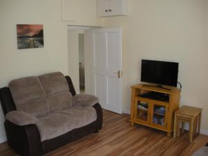 un soggiorno con divano e TV a schermo piatto di Beautiful 3-Bed House in Knock a Knock