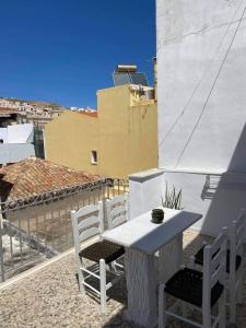 a white table and chairs on a balcony at Porto in Ermoupoli