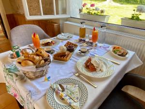 a table with plates of food on a table at Sans Souci Bed and Breakfast with Luxe Heated Pool in Luzillé