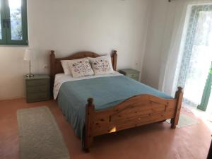 1 dormitorio con 1 cama de madera y 2 almohadas en Rocky Mountain Way - Off The Cretan Track en Sellía