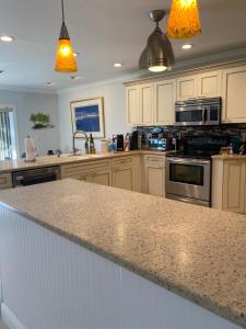 a kitchen with white cabinets and a granite counter top at This Homestay Oasis Is The Cape's Best Place To Stay in Cape Coral
