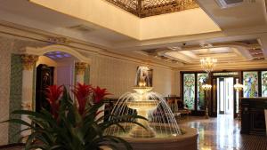 a lobby with a fountain in the middle of a building at Nabat Palace Domodedovo in Voyevodino