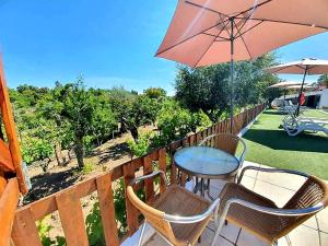 a patio with a table and chairs and an umbrella at Monte Família Ferreira in Vale de Açor +12 photos