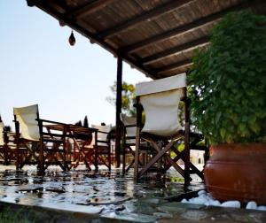 a patio area with chairs, tables and umbrellas at Ilios and Irene in Mastihari