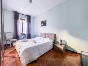 ein Schlafzimmer mit einem Bett und einem Stuhl darin in der Unterkunft MYHOUSE INN LINGOTTO - Affitti Brevi Italia in Turin