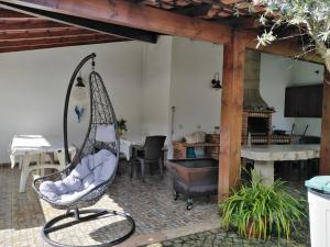 a patio with a swing chair and a fireplace at Quinta de São João in Poios