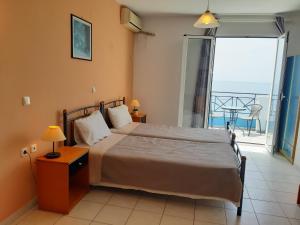 1 dormitorio con 1 cama y vistas al océano en Casa De Blue Studios & Apartments, en Lourdata