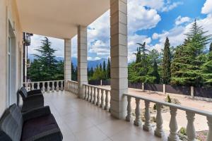 a balcony with chairs and a view of the mountains at Кристалл in Alushta