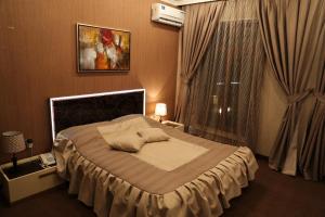 um quarto com uma cama grande e uma janela em Luxe Lankaran Hotel em Lankaran