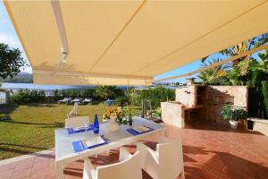 einen weißen Tisch und Stühle unter einem gelben Regenschirm in der Unterkunft Casa Mediterraneo in Alcúdia
