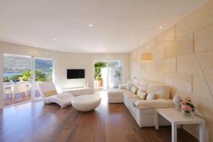 ein Wohnzimmer mit einem weißen Sofa und einem Fernseher in der Unterkunft Casa Mediterraneo in Alcúdia