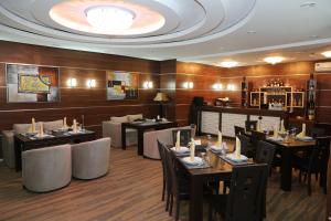 a restaurant with tables and chairs in a room at Luxe Lankaran Hotel in Lankaran
