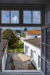 蓬塔德爾加達的住宿－CC Guest House - "Ao Mercado"，阳台享有带雨伞的房屋美景