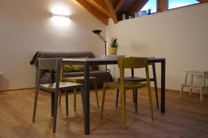 a dining room table with four chairs and a lamp at Agritur Zuveith in Salorno sulla Strada del Vino