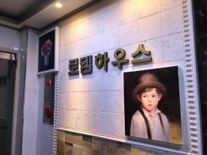 een schilderij van een jongen met een hoed op een muur bij Rodemhouse in Seoul