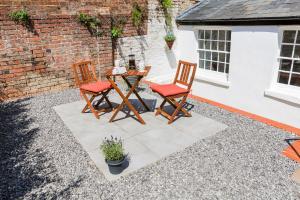 a patio with two chairs and a table in front of a building at 6 Elizabeth House - By Luxury Apartments in Cheltenham