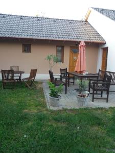 un patio con mesa, sillas y sombrilla en Gyöngy Vendégház, en Szekszárd