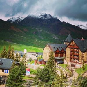 a town with a mountain in the background at Apartamentos Formigal - admite mascotas in Formigal