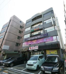 een gebouw waar auto's voor geparkeerd staan bij Rodemhouse in Seoul