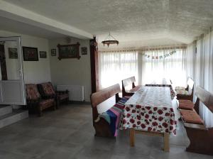 a dining room with a table and chairs and a window at Cabana Roșia in Roşia