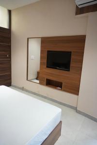 a bedroom with a flat screen tv and a mirror at Era hotel in Ambāla