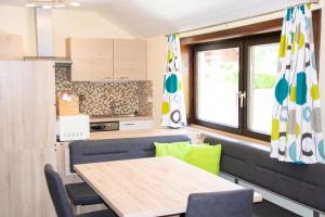 a dining room with a table and a kitchen at Strandhotel Burgstaller in Feld am See