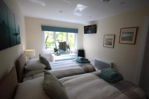 a room with three beds in it with a window at The Cabin at Easter Arr in Auldearn