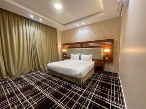 a hotel room with a bed and a large window at Shatha Abha Furnished Units in Abha