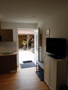 a kitchen with a television and a door to a patio at Ferienwohnung Kleines Nest in Hohendodeleben
