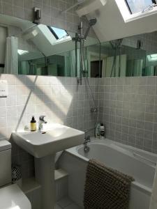 a bathroom with a sink and a tub and a mirror at The Old English Rooms in Falmouth +18 photos