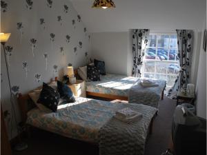 sypialnia z 2 łóżkami i oknem w obiekcie College Guest House w mieście Haverfordwest